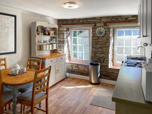 a kitchen with a table and a dining room at Cauldron Falls in West Burton