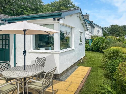 a table and chairs with an umbrella on a patio at Fron - Cottage in Mynfford