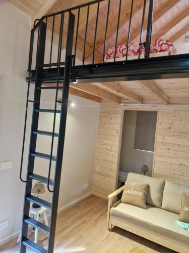 a loft bed in a room with a couch and a ladder at In het sprookjesbos in Zonnebeke