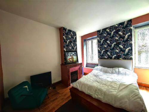 a bedroom with a bed and a chair in it at Chez Mina in Saint-Béat