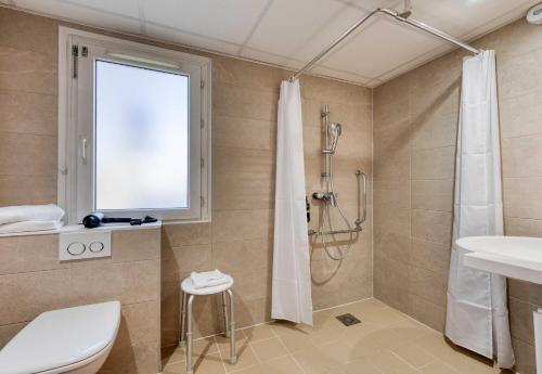 a bathroom with a shower and a toilet and a sink at B&B HOTEL Bordeaux Mérignac Cadera Aéroport in Mérignac