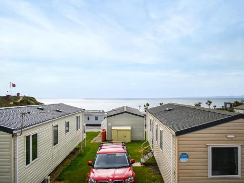 a row of tiny homes with a car parked between them at Apple Grove 24 in Exmouth