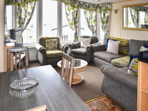 a living room with couches and a table at Apple Grove 24 in Exmouth
