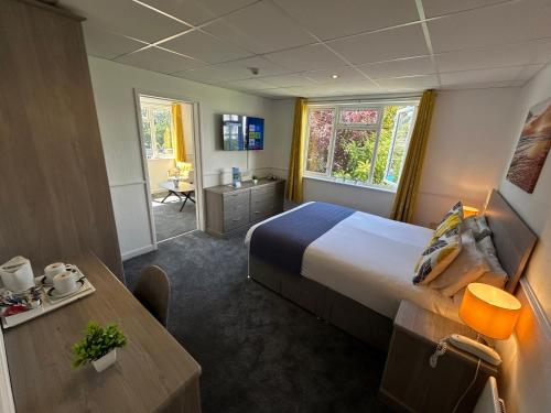 a hotel room with a large bed and a desk at Westhill Country Hotel in Saint Helier Jersey