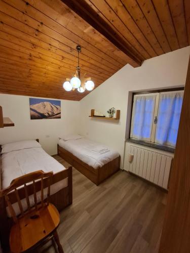 a bedroom with two beds and a wooden ceiling at Apartment Pineta Alben 2 in Serina