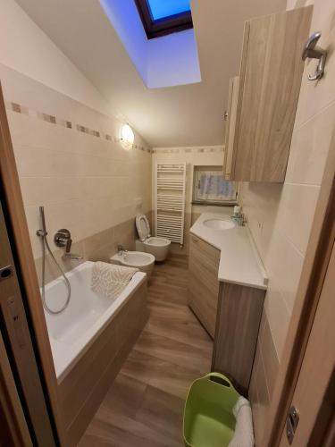 a bathroom with a tub and a toilet and a sink at Apartment Pineta Alben 2 in Serina