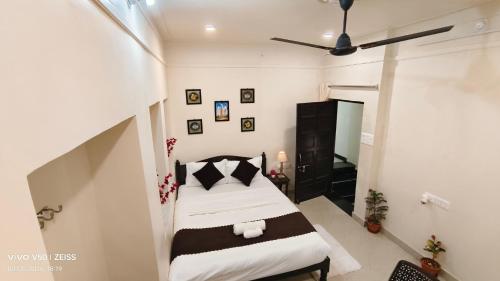 a bedroom with a bed and a ceiling fan at Parinuj homestay in Chittaurgarh