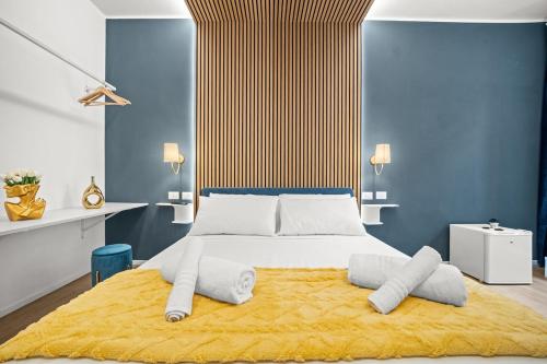a bedroom with a large bed with a yellow rug at Hidden Pyramid Suites in Rome