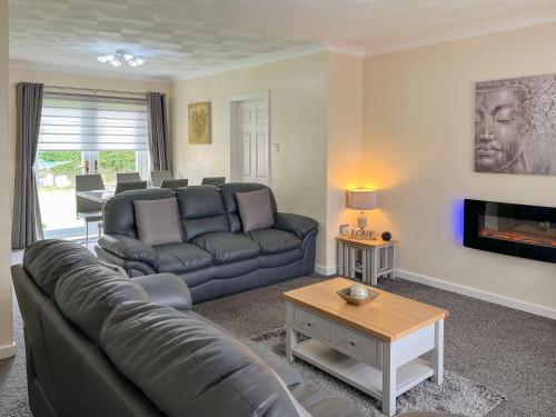 a living room with a couch and a tv at White Towers - Hw7625 in Llandwrog