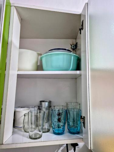 a cupboard with bowls and glasses on it at Casa no centro de Poços de Caldas in Poços de Caldas