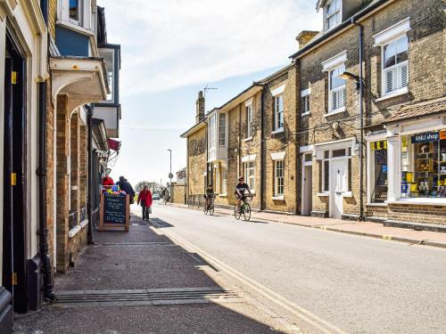 people riding bikes down a street with buildings at The Photographer's House in Southwold