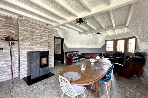 a living room with a table and a fireplace at Chaumière cosy avec SPA Baie de somme in Abbeville
