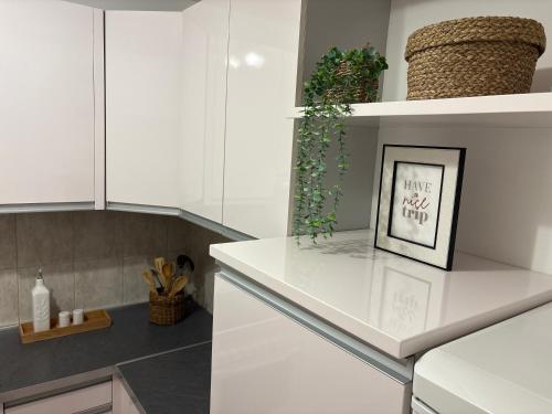 a kitchen with white cabinets and a picture on a counter at Boke vidik in Savina