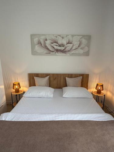a bedroom with two beds with two lamps on them at Malina Residence Aparthotel in Cisnădie