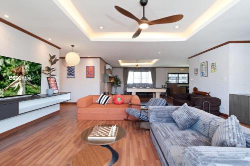 a living room with a couch and a ceiling fan at Capitel Ekkamai Hotel in Sathani Khlong Tan