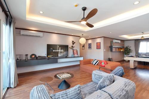 a living room with two couches and a tv at Capitel Ekkamai Hotel in Sathani Khlong Tan