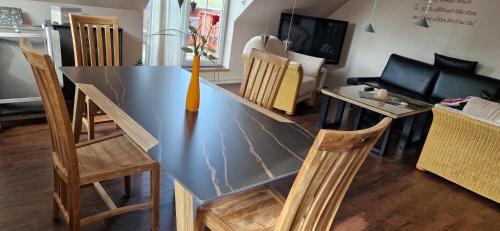 a dining table and chairs in a living room at Luxuswohnung, 90 qm, Balkon, beste Lage in Kollmar in Kollmar