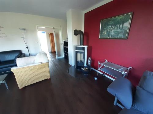 a living room with a white couch and a red wall at Luxuswohnung, 90 qm, Balkon, beste Lage in Kollmar in Kollmar