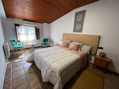 a bedroom with a bed and a table and chairs at Casa Rural Valle del Jerte in Jerte