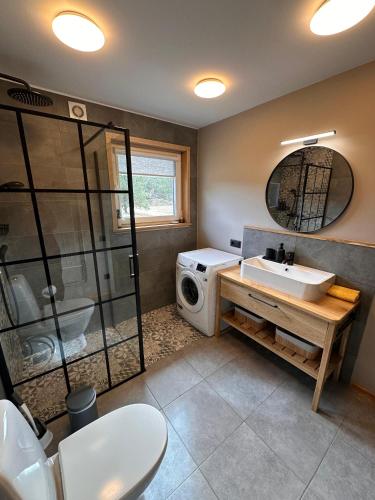 a bathroom with a sink and a washing machine at Jūrmalciema Pērle AMBER in Jūrmalciems