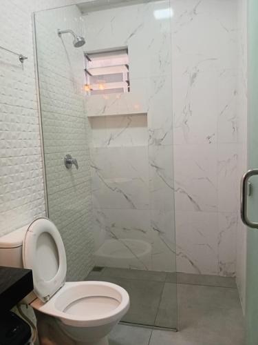 a bathroom with a toilet and a glass shower at Hostal Center A in Santa Cruz de la Sierra