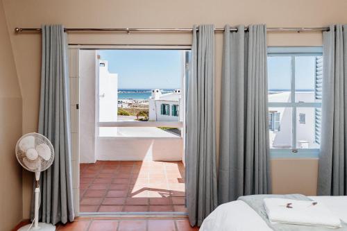 a bedroom with a bed and a view of the ocean at Duifie in Paternoster