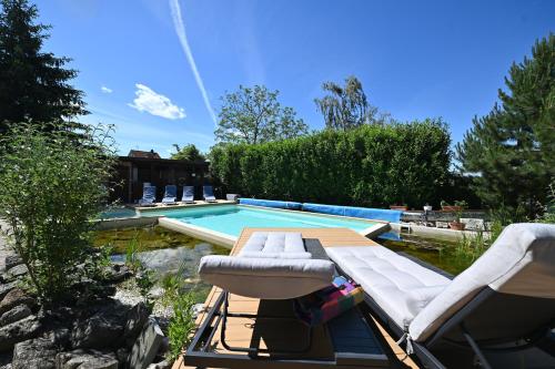 a swimming pool with two lounge chairs next to a swimming pool at Vintage Home Vendégház in Miskolctapolca