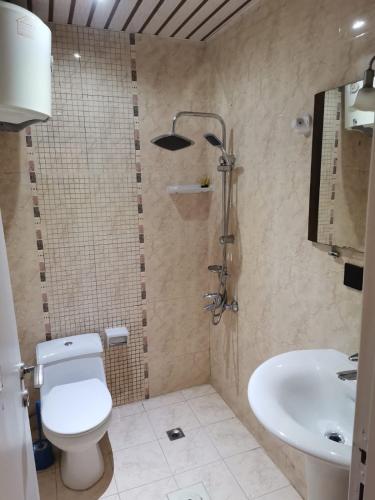 a bathroom with a toilet and a sink at جولدن نيو الدار للشقق المخدومة in Jazan