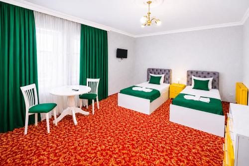 a hotel room with two beds and a table at Sultanahmet Hotel in Baku