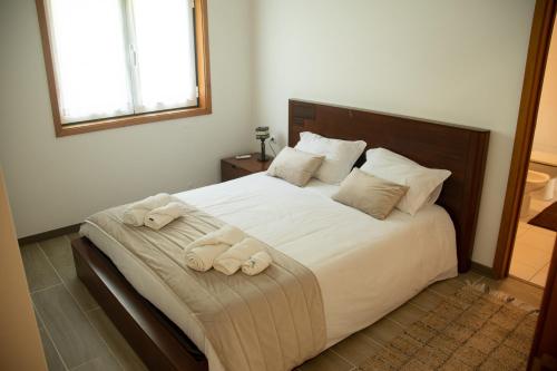a bedroom with a large bed with towels on it at Quinta da Caselinha in Paredes de Coura