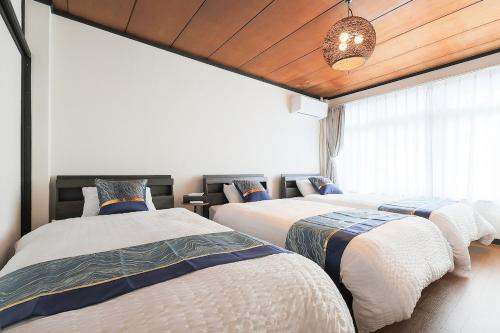 a bedroom with two beds and a window at 宿丸一 in Tajimi