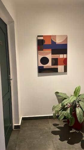 a plant sitting in front of a painting on a wall at Narjis in Dzaoudzi