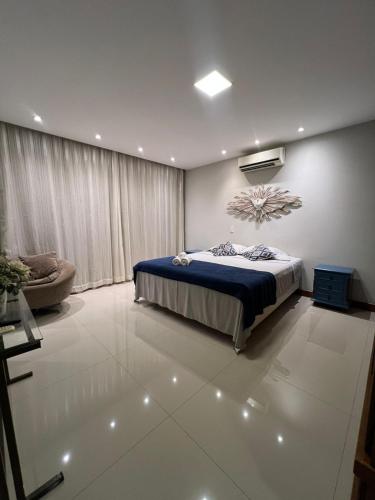 a bedroom with a bed and a couch at Apartamento amplo João VI in Muriaé
