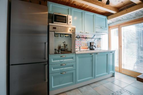 una cucina con armadi blu e frigorifero in acciaio inossidabile di Charming old stone house a Sali (Sale)