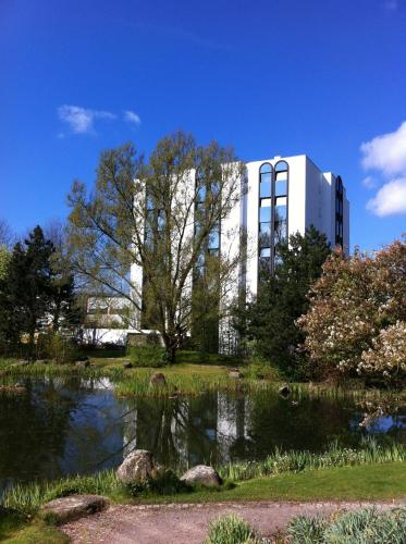 a building with a pond in front of a building at Atrium im Park Hotel Regensburg in Regensburg