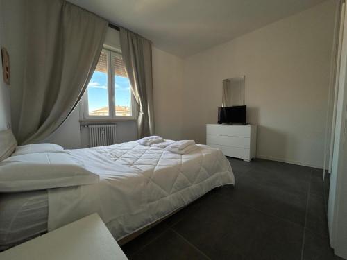 a bedroom with a white bed and a window at Residence Greta in Parma