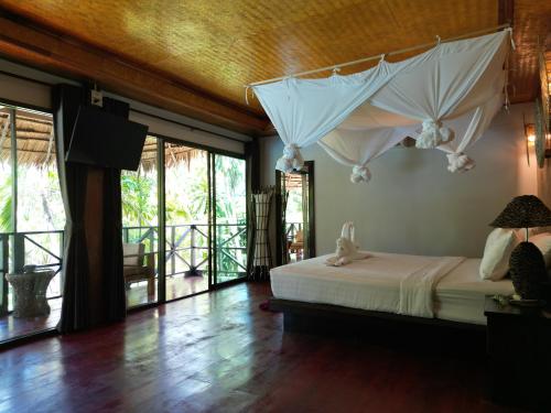a bedroom with a bed with umbrellas on the wall at Garden Chalets Koh Lanta in Ko Lanta