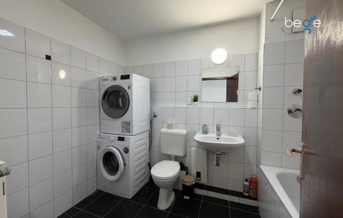 a bathroom with a washer and a toilet and a sink at BEGE APARTMENTS HomeAway in Marl