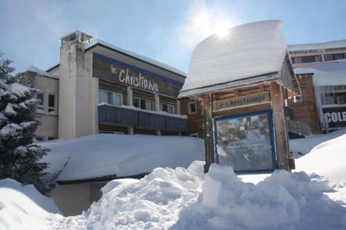 a sign in a pile of snow in front of a building at Le Christiania in Saint-Lary-Soulan