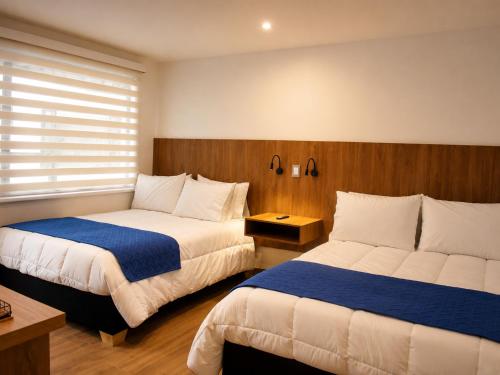 a hotel room with two beds and a window at Casa Siete Hotel Boutique in Bogotá