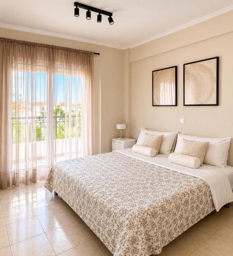 a bedroom with a large bed and a large window at Agapidis Apartment in Hanioti
