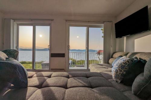 a living room with a couch and a view of the water at Chalet #8 Waterfront with Spa, Fireplace, Wifi and AC in Cap-Saint-Ignace