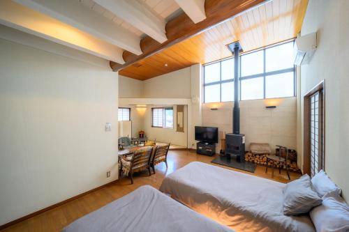 a bedroom with two beds and a living room at Good MorningHouse in Takayama