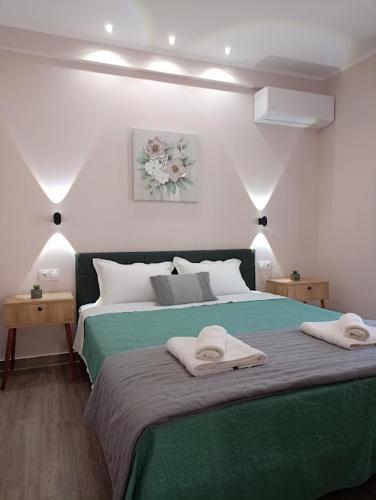 a bedroom with a green bed with towels on it at Celestia Irene Suites 2 in Vromerí
