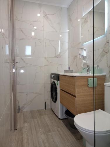 a bathroom with a toilet and a sink and a shower at Celestia Irene Suites 2 in Vromerí