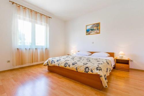 een slaapkamer met een bed en een groot raam bij Apartments Cukon in Medulin