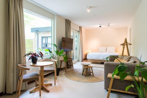 a room with a bed and a couch and a table at Van Heeckeren City Centre Studios Nes in Nes