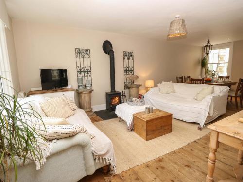 a living room with a bed and a fireplace at Fern Cottage in Bembridge