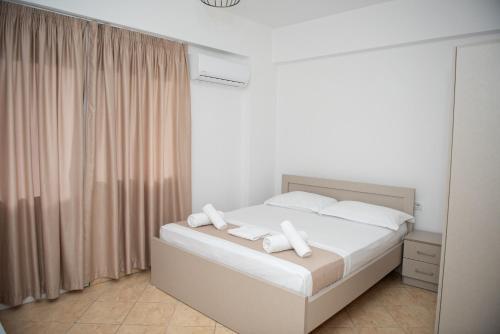 ein Schlafzimmer mit einem Bett mit weißen Laken und Kissen in der Unterkunft Deve Mar Hotel in Borsh