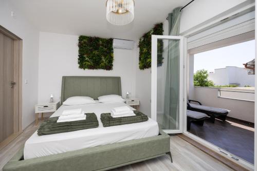 a bedroom with a large bed and a balcony at Apartments Milas in Okrug Gornji